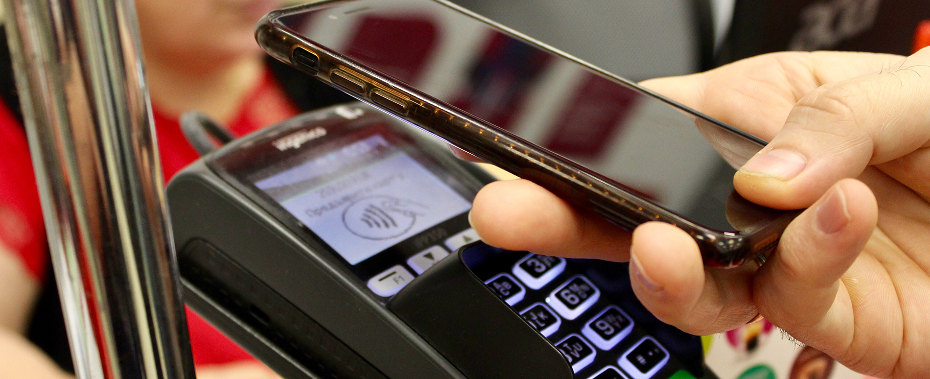 Persona pagando una cuenta con la funcion Proximidad NFC